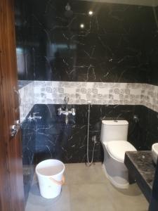 拉特纳吉里Samarth Homestay的一间带卫生间和黑色墙壁的浴室