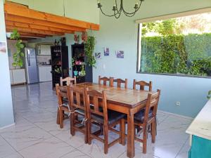 圣卡洛斯-德巴里洛切hermosa casa a una cuadra del lago的一间带木桌和椅子的用餐室