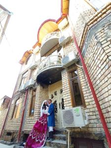 撒马尔罕Samarkand Сity Guest House的站在建筑物前的男女