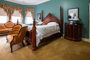 斯普林菲尔德Exquisite Victorian的一间卧室配有一张大床和一把椅子