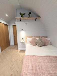 亚瑟斯通Gopsall Hall Farm的卧室配有白色的床和枕头。