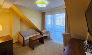 克罗奇琴科Pensjonat Crosna SPA的酒店客房设有沙发和窗户。