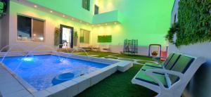 雷伊斯اوس الحجاز的一个带椅子和浴缸的房间的游泳池