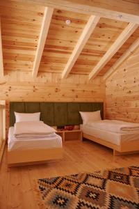 沃罗赫塔MOKHY Chalet & Nature的配有木天花板的客房设有两张床。