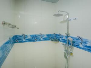 图杜Vegas Thoddoo Maldives的浴室设有蓝色瓷砖,墙上设有淋浴。