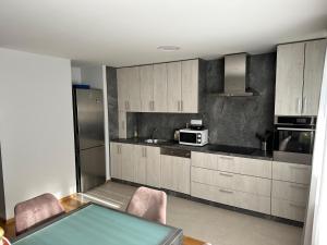 萨格勒布Apartman PEPI的厨房配有桌椅和微波炉。