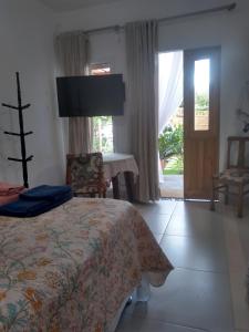 皮涅拉Vila Sabará的一间卧室配有一张床、一张桌子和一个窗户。