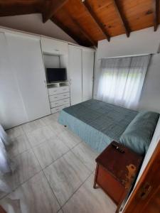 内科切阿Necochea-Casa para hasta 4 personas!的一间卧室配有一张床和一台电视