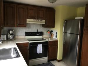 WaretownAwesome Apartment In Barnegat Light With 3 Bedrooms And Wifi的厨房配有木制橱柜和不锈钢冰箱。