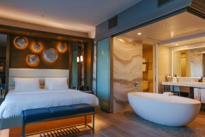 曼哈顿海滩曼哈顿海滩酒店的一间卧室设有一张大床和一个浴缸