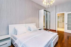巴库Vip Apartment Zanzibar的卧室配有一张带吊灯的大型白色床。