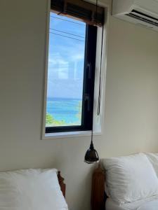 读谷村senahahausub03的一间卧室设有海景窗户