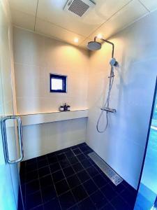 读谷村senahahausub03的浴室铺有黑色瓷砖地板,设有淋浴。
