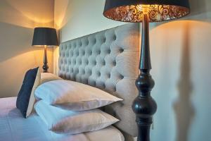 凯库拉凯库拉精品酒店的一间卧室配有带枕头和台灯的床