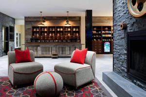 埃德门兹顿Four Points by Sheraton Edmundston Hotel & Conference Center的大堂设有两把椅子和壁炉