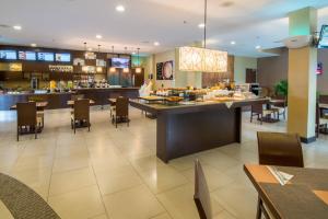 阿拉胡埃拉阿拉胡埃拉圣荷西机场万怡酒店的餐厅设有早餐吧和桌椅