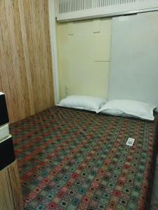 孟买Near Airport AC Double Room at a Budget Inn的一间设有两张床的客房,地板上铺有地毯。