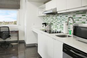 迈阿密迈阿密多拉元素酒店的厨房配有白色橱柜、水槽和窗户。