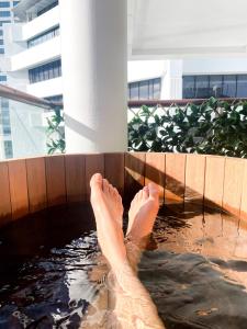 奥克兰Luxury Apartment - Parking - Hot Tub - Stunning Views的脚踏入水中的人