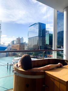 奥克兰Luxury Apartment - Parking - Hot Tub - Stunning Views的坐在浴缸中的女性,在一间享有美景的房间里