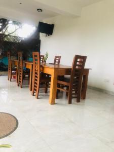 波隆纳鲁沃Senanayaka Holiday Inn的木制餐桌和木椅
