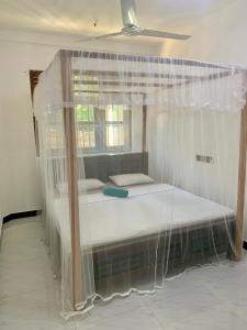 米迪加马东Aldea bleu的窗户客房内的一张带天蓬的床