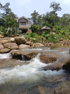 Padang RengasDango1881muslim riverstay的房屋前有岩石的河流