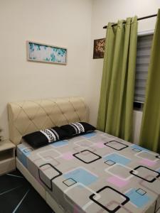 实兆远Lekir baiduri homestay的绿窗帘的房间的一张床位
