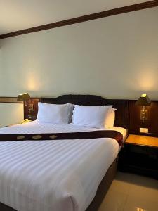 北柳桑塔拉健康度假酒店的卧室配有一张带白色床单和枕头的大床。