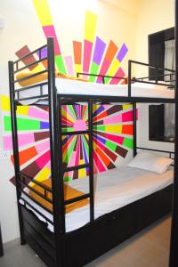 孟买Prince Solo Hostel的一间卧室配有一张双层床,拥有色彩缤纷的墙壁