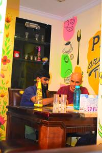 孟买Prince Solo Hostel的坐在餐厅桌子上的两个人