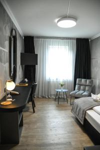 德利茨希祖姆维森罗斯酒店的一间卧室配有一张床、一张书桌和一个窗户。