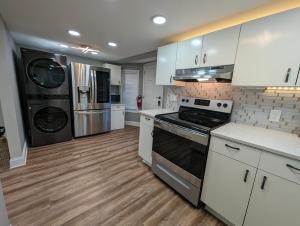 玛丽埃塔市Modern Luxe Family & Groups Friendly Bungalow with Patio & Workspace的厨房配有白色橱柜和炉灶。
