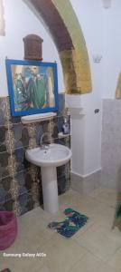 卢克索Golden Palace Garden的一间带水槽的浴室和墙上的绘画