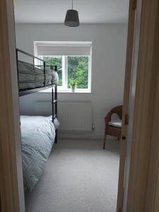 卡纳芬Peaceful marina-side house in north Wales的一间卧室配有双层床和窗户。