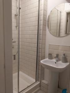 卡纳芬Peaceful marina-side house in north Wales的白色的浴室设有水槽和淋浴。