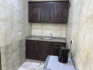 杰拉什Dream Hotel jerash的厨房配有棕色橱柜和水槽
