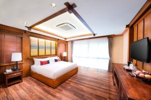 清迈Phra Singh Village的一间卧室配有一张床和一台平面电视