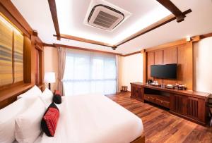 清迈Phra Singh Village的一间卧室配有一张大床和电视