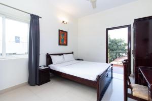 班加罗尔Sanctum Suites Indiranagar Bangalore的一间卧室设有一张床和一个阳台
