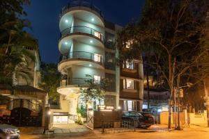 班加罗尔Sanctum Suites Indiranagar Bangalore的前面有停车位的建筑