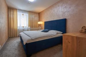 多纳瓦利Donovaly Residence Apartment 111的一间卧室配有蓝色的床和蓝色床头板