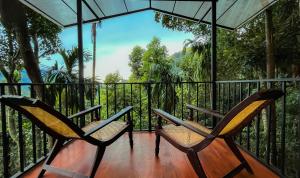 埃拉斯里兰卡爱瑞那生态酒店和瑜伽中心的阳台上配有两把椅子,享有丛林美景