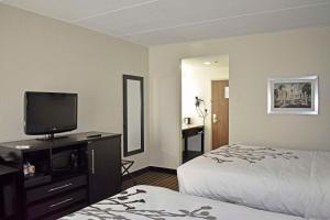 诺克斯维尔Sleep Inn & Suites West Knoxville的配有一张床和一台平面电视的酒店客房