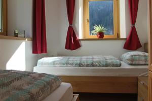 拉维拉Ciasa Alfri的一间卧室设有两张床和窗户。
