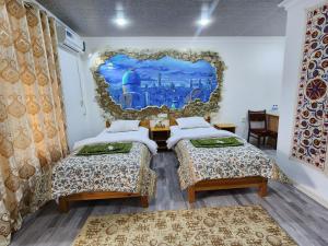 布哈拉布哈拉萨曼尼住宿加早餐旅馆的墙上壁画的房间里设有两张床