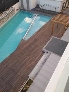 格兰贝伊Paille en Queue apartment的一个带木甲板和长凳的游泳池