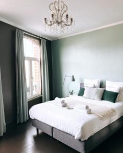登德尔蒙德Domus Portus的卧室配有一张带吊灯的大型白色床。