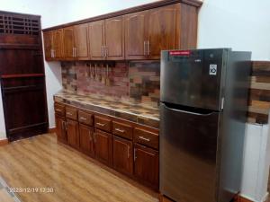 KattankudiGunam Residence的厨房配有木制橱柜和不锈钢冰箱。