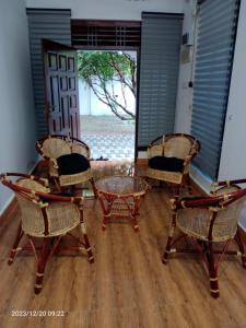 KattankudiGunam Residence的一间设有三把椅子和一张玻璃桌的房间
